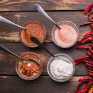 set-sauces-bowls-with-spoons-near-chili