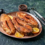 front-close-view-delicious-fried-fishes-lemon-slices-brown-plate-pepper-mix-colors-table-with-free-space